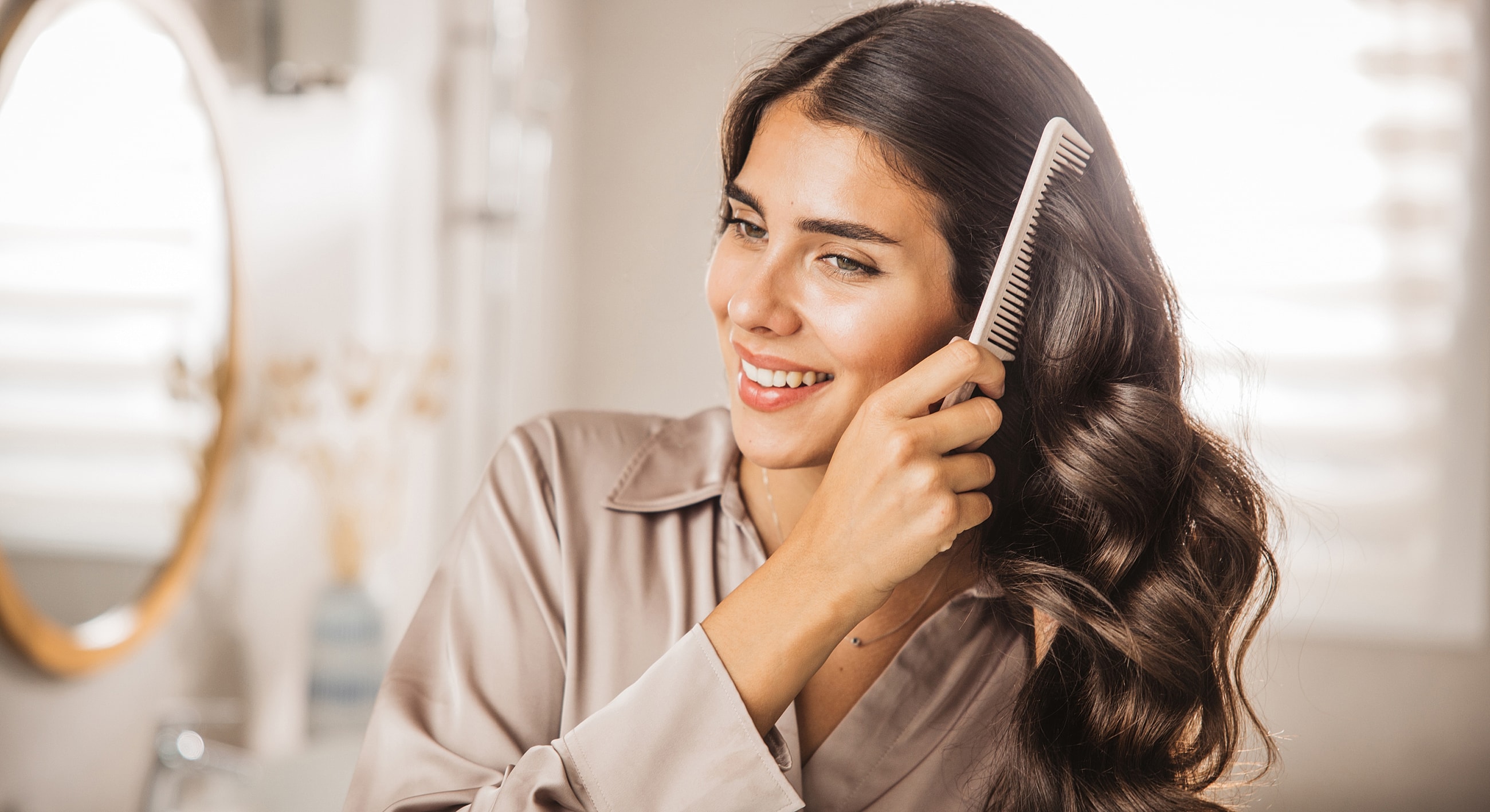 Woman combing her hair in soft lighting.
