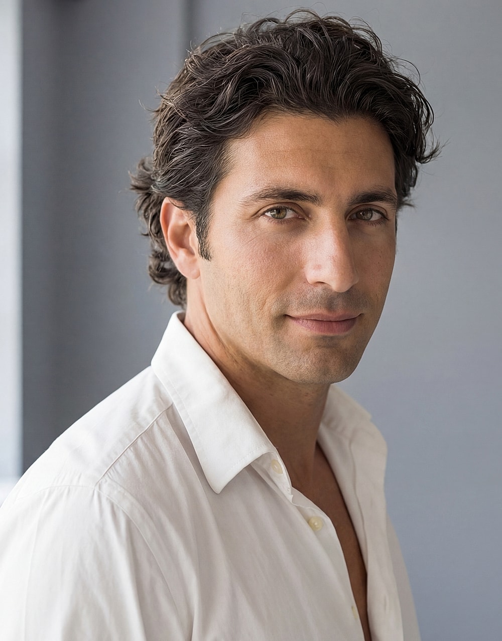 Portrait of a man with dark, wavy hair.