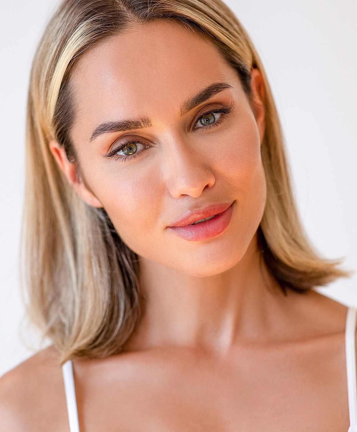 Smiling woman with blonde hair and glowing skin