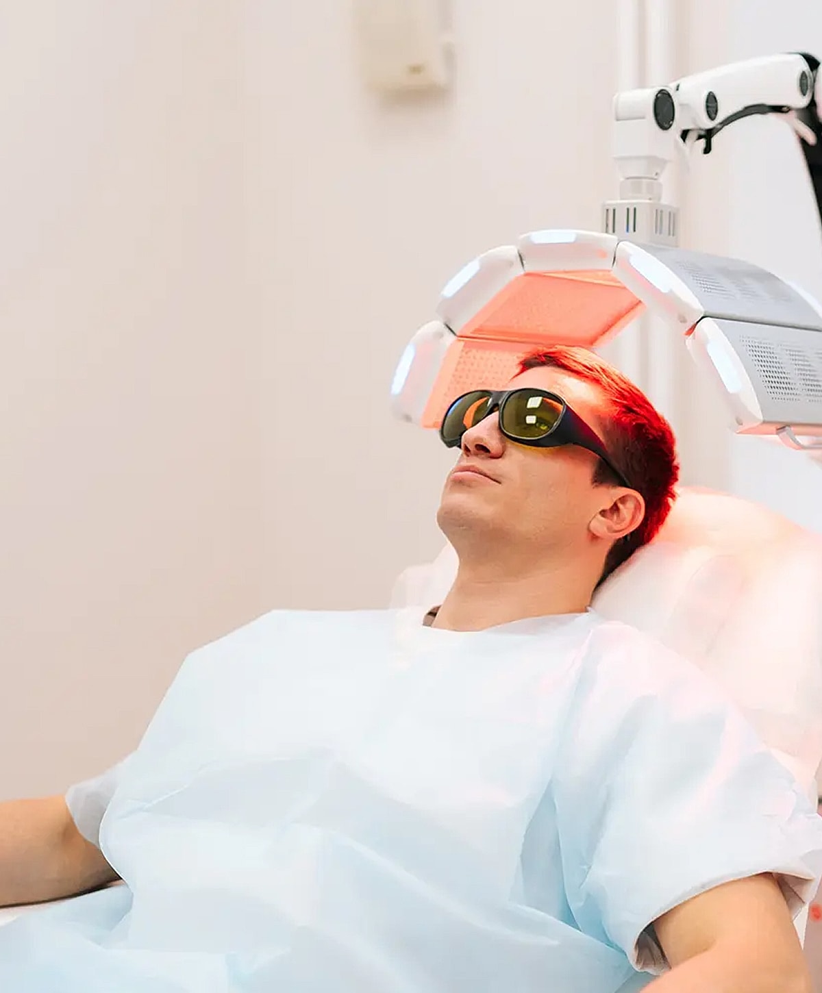 Man undergoing light therapy treatment in clinic.