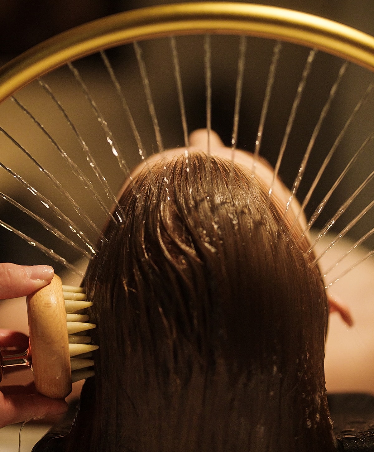 Brushing wet hair with a wooden comb.