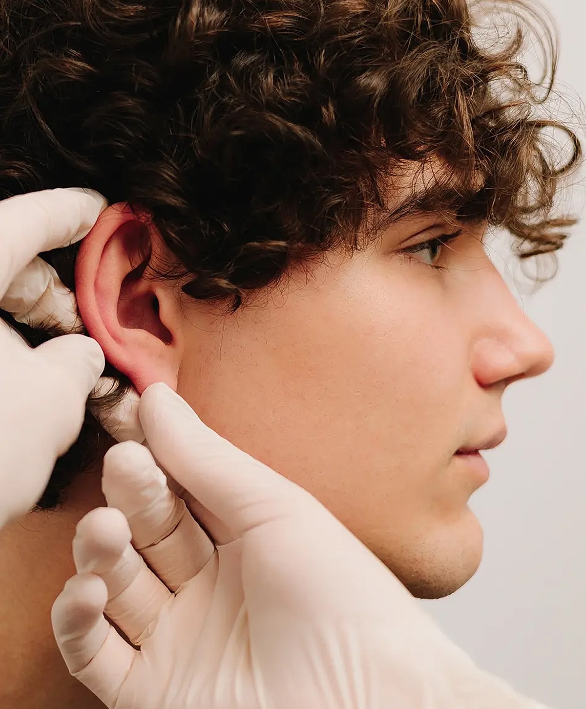 Healthcare professional examining a young man's ear