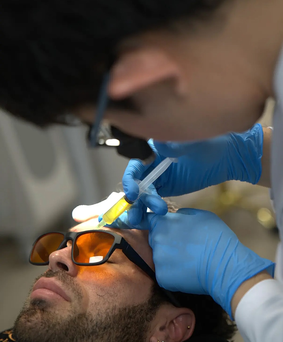 Medical procedure with patient wearing protective sunglasses.