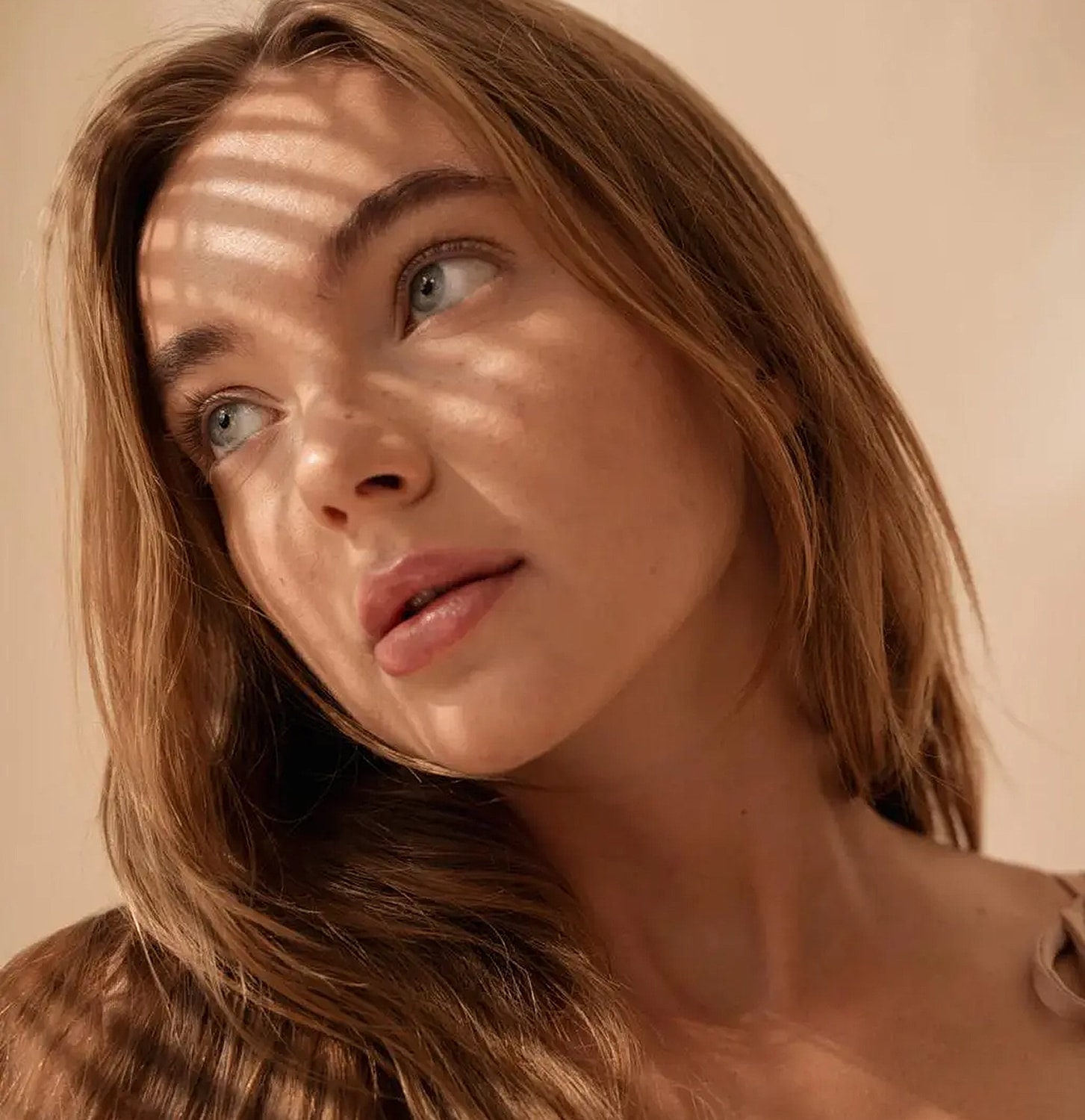 Model with sunlight shadows on her face.