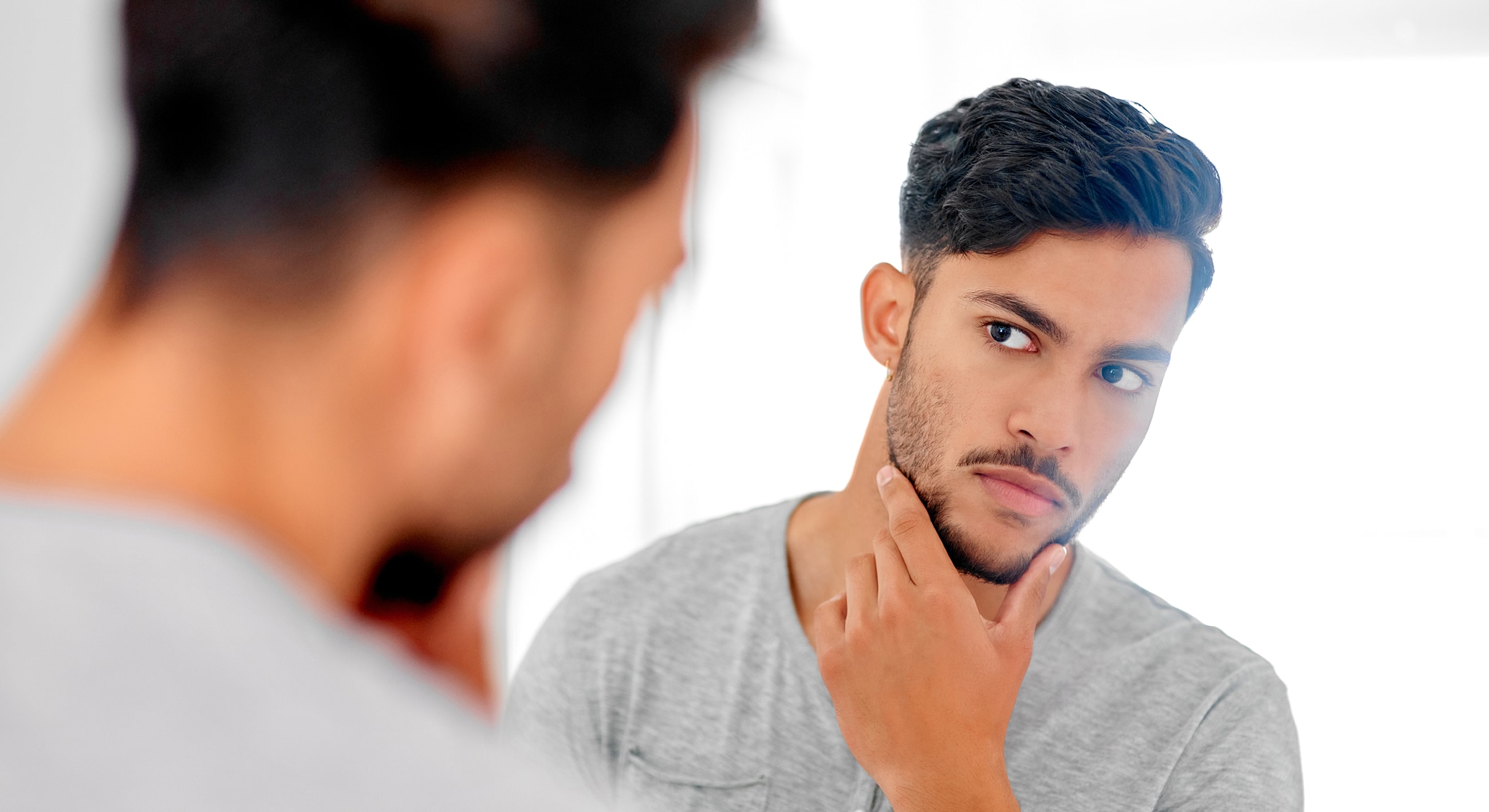 Man grooming in front of a mirror.