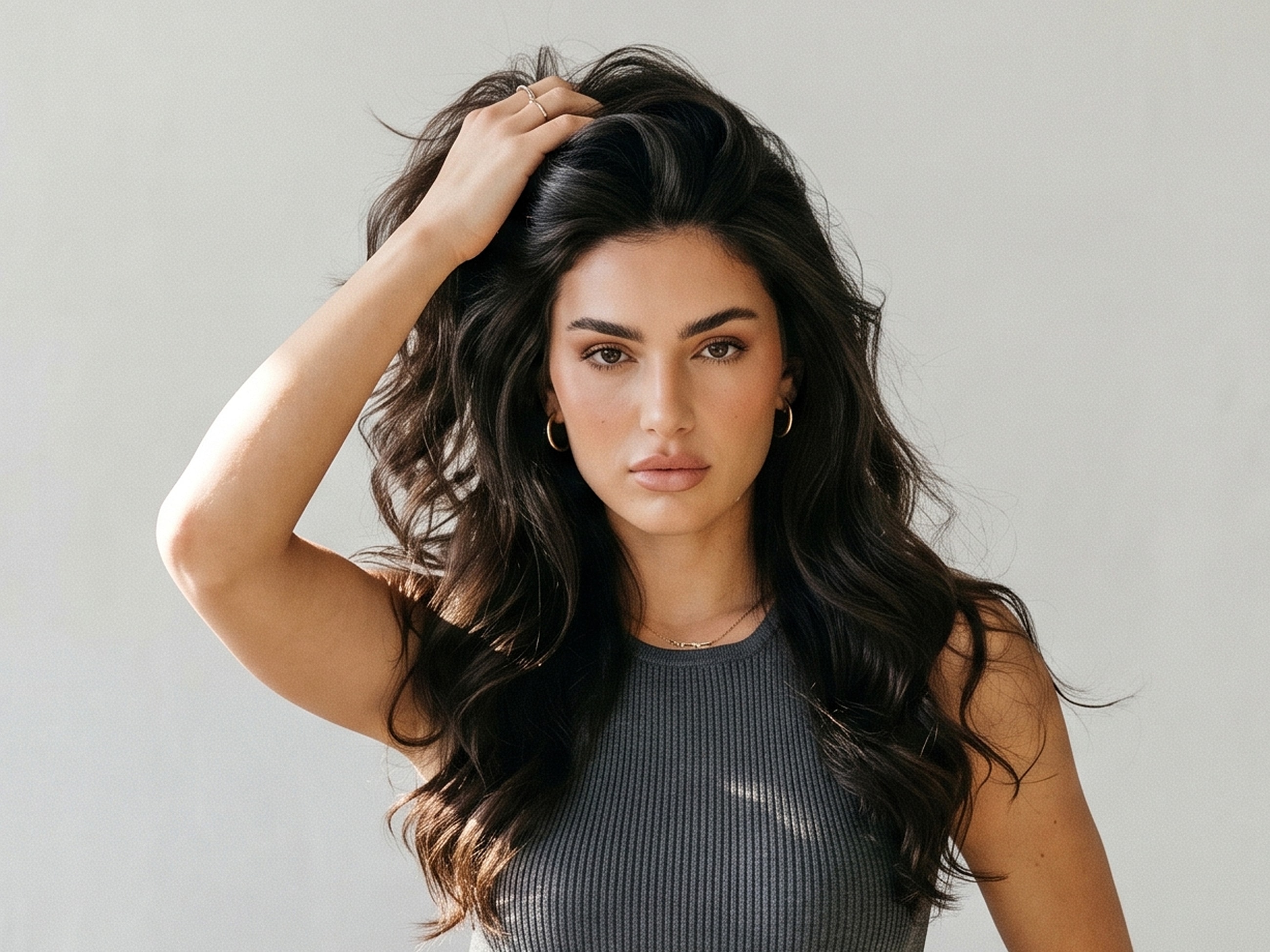 Woman with wavy hair posing confidently.
